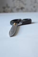 hand holding large metal scissors with black handle  ideal for themes like sewing, crafting,...