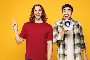 Young two friends buddies men they wear casual clothes together hold megaphone scream announces...