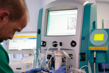 Doctor operating advanced medical equipment for blood transfusion or dialysis in hospital