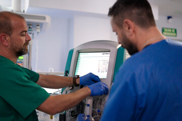 Doctors setting up medical equipment for patient treatment in hospital operating room