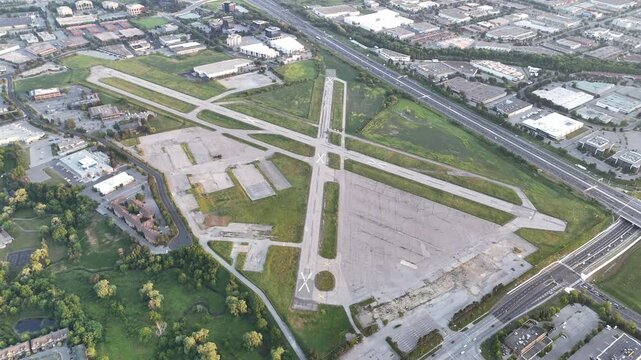 Wide aerial shot of drone circling decommissioned Buttonville Airport runway and adjacent Highway 404 with visible traffic during daylight