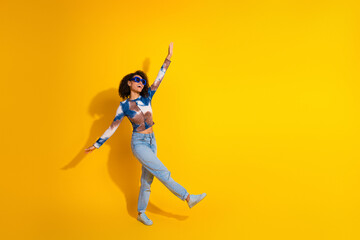 Energetic Young Woman in Stylish Attire Posing on Yellow Background Expressing Fun and Confidence