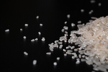 White rice in a wooden bowl set against a black background