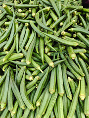Fresh Okra for Sale at a Local Market, A vibrant pile of fresh green okra, displayed for sale at a local market. People buy them directly for home cooking.
