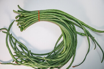 A bundle of fresh yardlong beans (Vigna unguiculata) isolated on white background