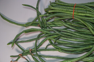 A bundle of fresh yardlong beans (Vigna unguiculata) isolated on white background