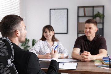 Couple having meeting with business consultant at table in office, selective focus