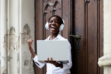 Portrait of happy black African student holding laptop and studying at the college.