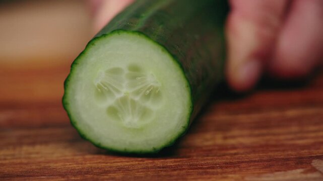Cinematic close-up of a man's hands slicing a cucumber with Japanese knife &ndash; slow motion food prep, minimalist kitchen, precision cutting. 