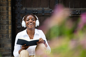 Portrait of happy black African student holding book and studying at the college.