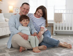 Fototapeta premium Cute little boy and his parents at home. Lovely family