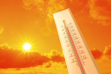Extremely high temperature on thermometer against orange sky on sunny day. Severely hot summer...