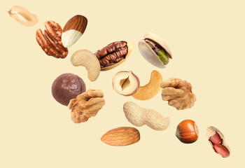 Peanut and other nuts flying on beige background