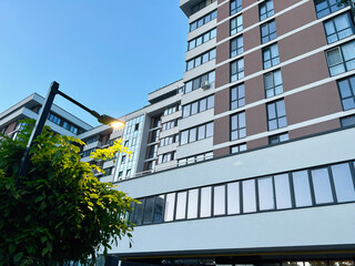 Modern apartment building with streetlight and greenery in evening light