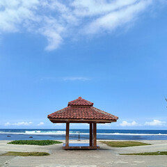 Traditional Joglo Gazebo on Coastal Landscape under Blue Sky