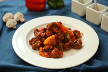 Szechuan Chicken which is a popular Indo-Chinese non vegetarian recipe. served in a plate with chilli sauce. selective focus