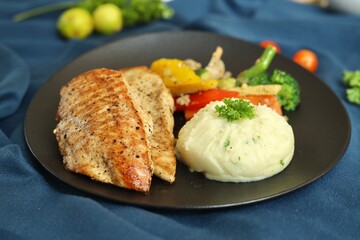 Grilled chicken with vegetables on the side served on a fancy white plate in a restaurant or cafe background 