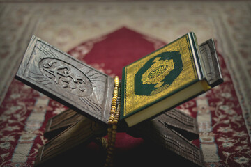 The Holy Alquran, holy book of Muslims and wooden prayer beads in a mosque