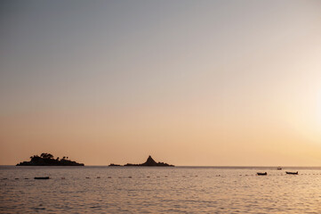 Serene Sunset Over Calm Sea with Distant Islands