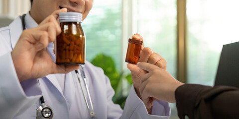 Patient Interaction. Doctor handing medication to patient during consultation.