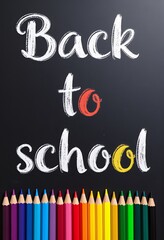 Back to school message handwritten with colorful pencils arranged below on a dark surface