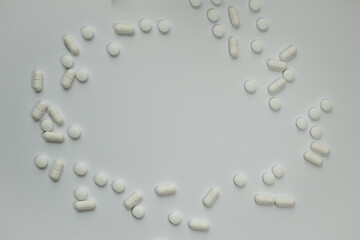 Calm white background with white pills arranged around the circumference of the text or symbol space