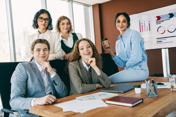 Group of business professionals collaborating in a modern office setting showcasing teamwork and...