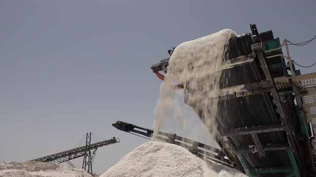 Tunisia industry and harvesting, salt rolls from conveyor belt onto pile in Chott el Jerid, the largest salt pan in the Sahara desert
