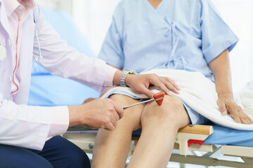 Orthopedic doctor checking on elderly woman knee.