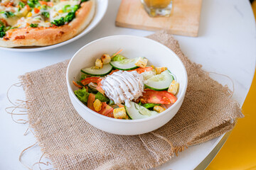 
Fresh vibrant salad with crisp vegetables, croutons, and creamy dressing, accompanied by pizza and drinks, perfect for a healthy and hearty meal.