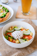 
Fresh vibrant salad with crisp vegetables, croutons, and creamy dressing, accompanied by pizza and drinks, perfect for a healthy and hearty meal.