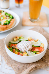 
Fresh vibrant salad with crisp vegetables, croutons, and creamy dressing, accompanied by pizza and drinks, perfect for a healthy and hearty meal.