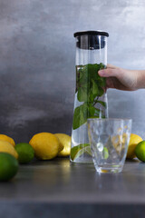 Homemade citrus refreshing summer lemonade drink with lemon, lime and mint in mason jars. Taste of...