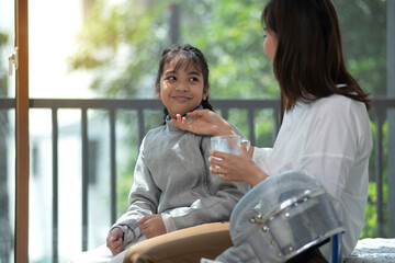 Fencing athlete, mother takes care of her daughter  by giving her milk to drink, caring for growing child concept.