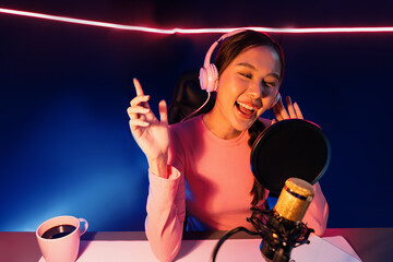 Host channel of young beautiful Asian broadcaster listening the music on social media with...