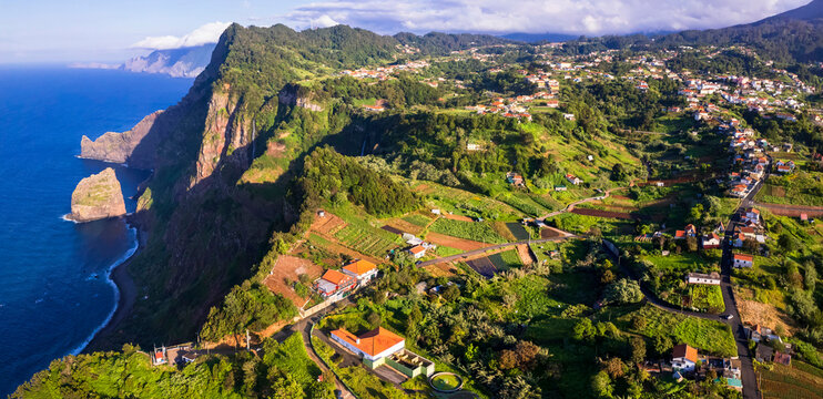 Madeira island beautiful nature scenic landscape. Aerial drone panoramic view of Santana and cliff Rocha do Navio over sunset. portugal