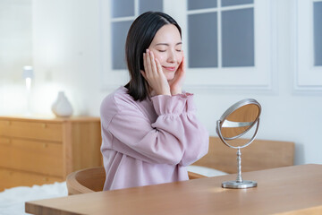 部屋で鏡を見る女性