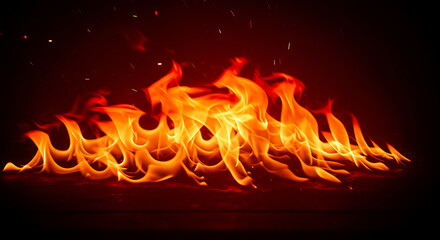 Fototapeta premium A line of intense, vibrant orange flames burning against a solid black background. A powerful symbol of fire, heat, energy, and danger. 