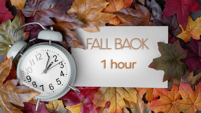 Autumn time change concept.  Fall Back 1 Hour message text with alarm clock surrounded by colorful fall foliage. - Powered by Adobe