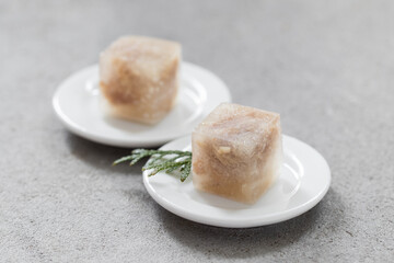 Jellied meat in the shape of a small cubes. On a plate