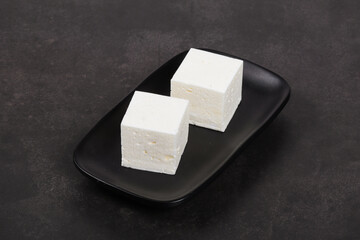 Bird's milk. Vanilla Souffle in the shape of a cube. On a black plate