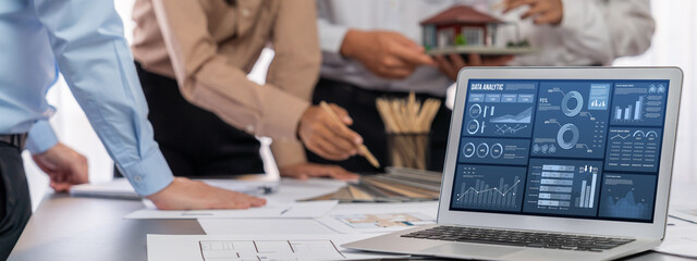 Group of interior architect designer discussing together on blueprint and laptop screen display...