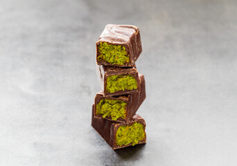 Chocolate pistachio candy. Dubai chocolate candy with crispy kataifi and pistachio paste. Close up. Dark background