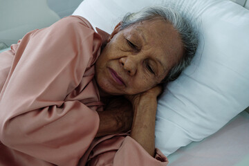 Elderly woman peacefully sleeping on hospital bed, representing rest, healing, and quality care for...