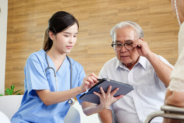 Female nurse explaining medical information on digital tablet to elderly male patient, showing patient education, clear communication, and trust in senior healthcare.