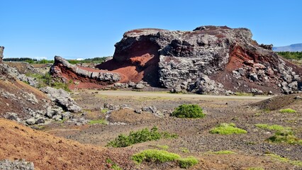 Red volcanic rock formations formed by lava in Iceland, abstract landscape