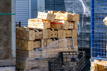 stack of wooden baskets with handles placed on a pallet, wrapped in stretch film, prepared for...