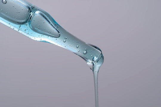Close up of a blue liquid cosmetic pipette