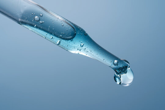 Cosmetic pipette with blue liquid close up