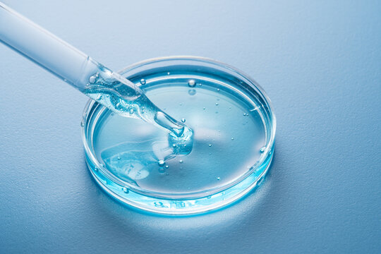 Cosmetic pipette with blue liquid in petri dish
